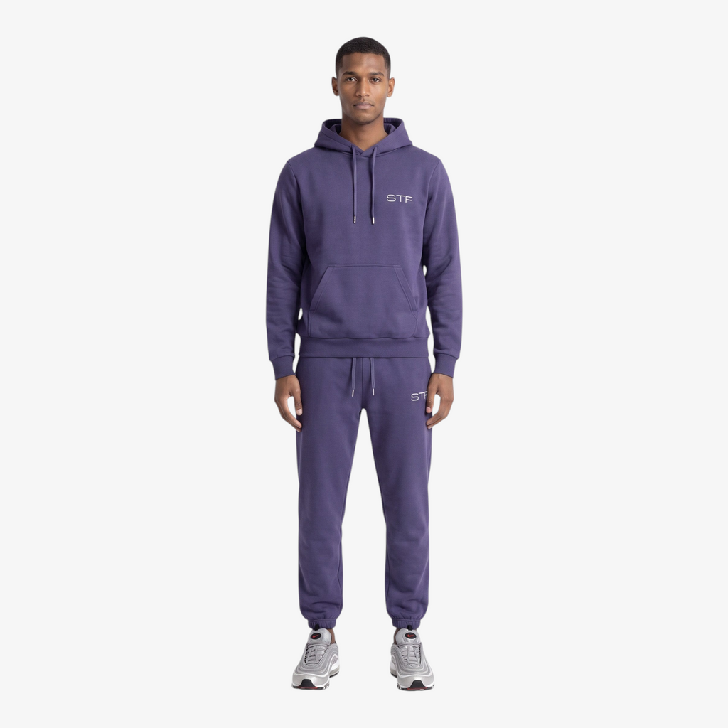 Model wearing a Seejthreadsflames (STF) purple heavyweight cotton tracksuit with an oversized hoodie and joggers.