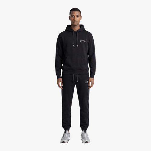 Model wearing a Seejthreadsflames (STF) black heavyweight cotton tracksuit with oversized hoodie and relaxed joggers.