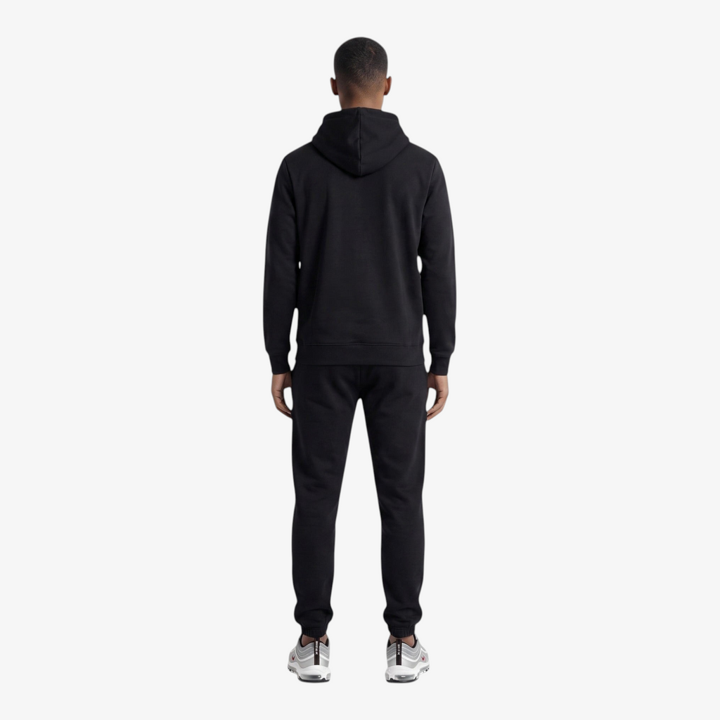 Back view of a man wearing a Seejthreadsflames (STF) black heavyweight cotton tracksuit with an oversized hoodie.