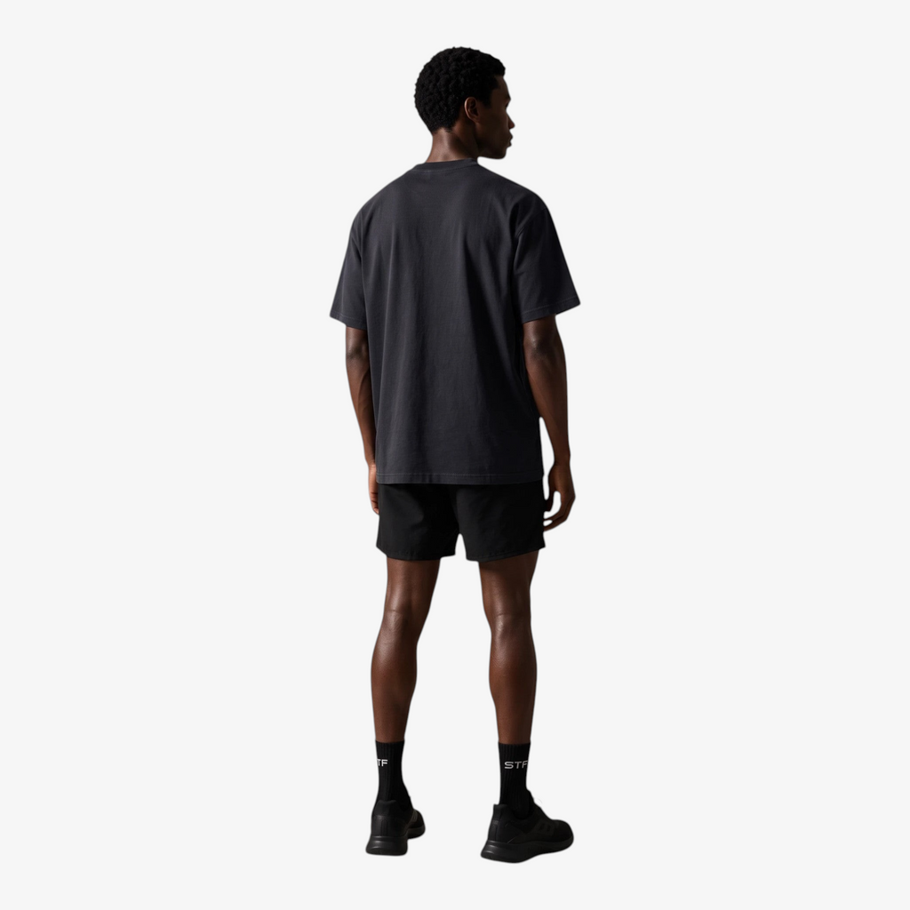 Back view of a man wearing a Seejthreadsflames (STF) black boxy cotton French terry t-shirt with dropped shoulders.