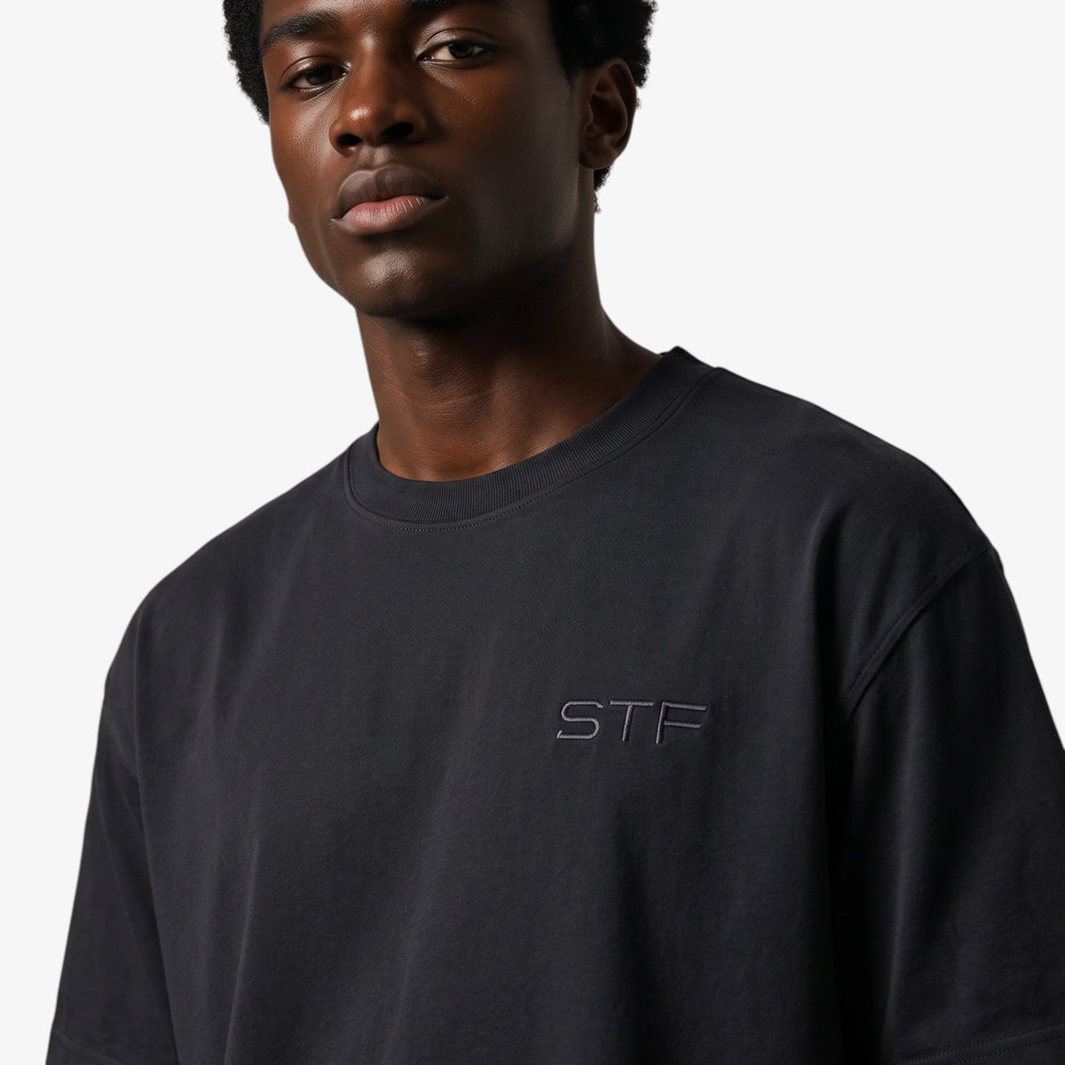 Model wearing a Seejthreadsflames (STF) black cotton French terry t-shirt with tonal chest embroidery