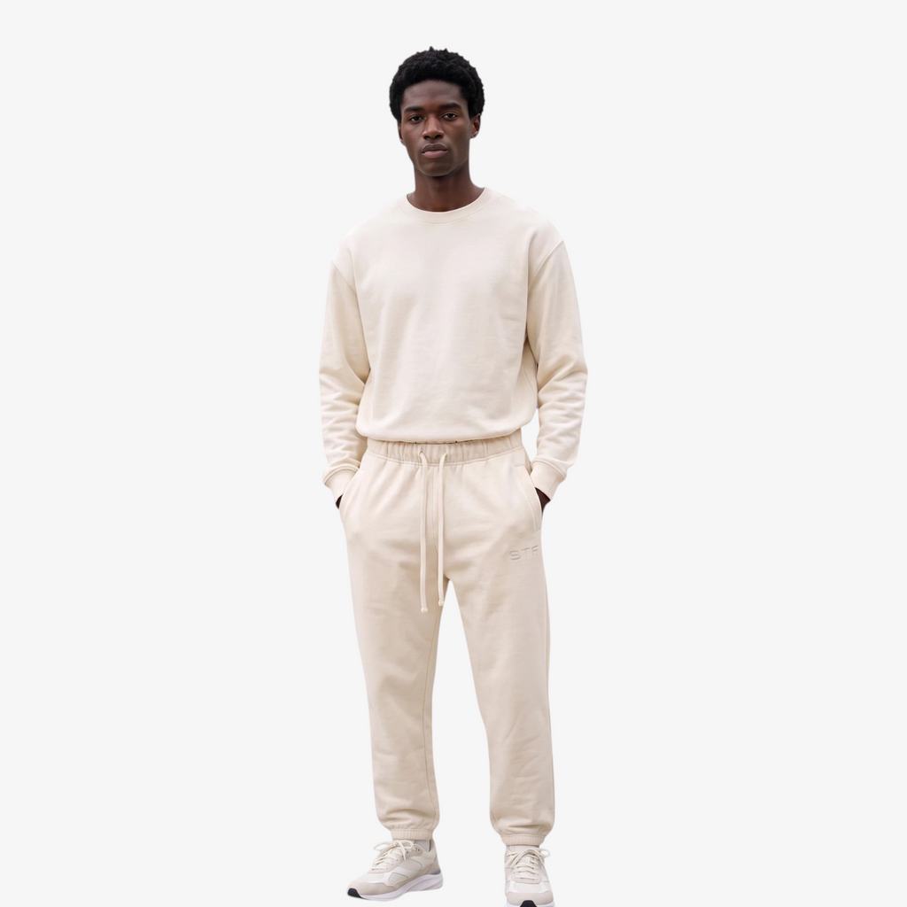 Model wearing Seejthreadsflames (STF) Essential Jogger in cream heavyweight fabric with elasticated cuffs and waist.