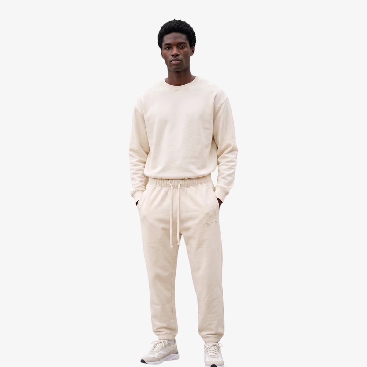 Model wearing Seejthreadsflames (STF) Essential Jogger in cream heavyweight fabric with elasticated cuffs and waist.