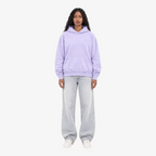 Model wearing a Seejthreadsflames (STF) lavender pullover hoodie with chest embroidery, paired with light wash jeans.