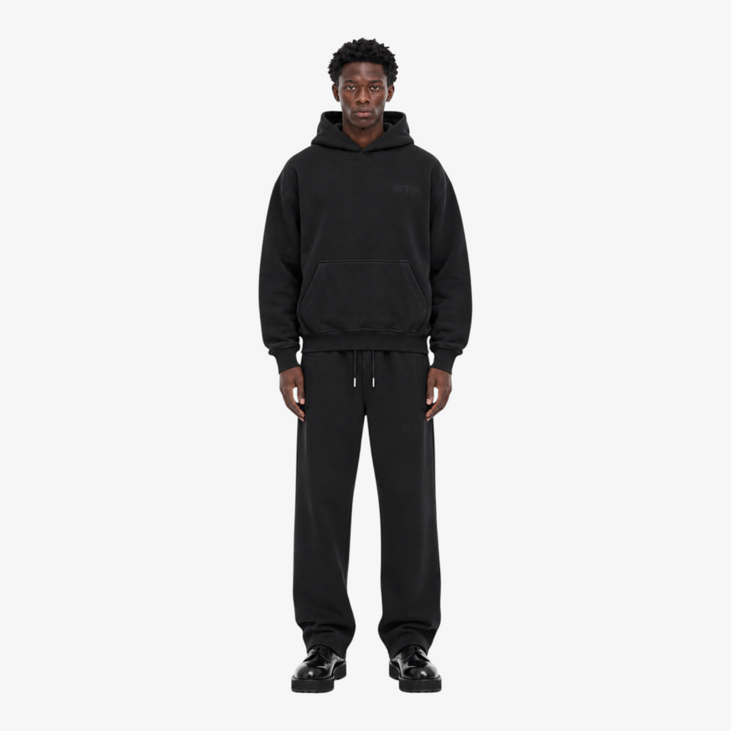 Male model wearing the STF black heavyweight tracksuit, front view