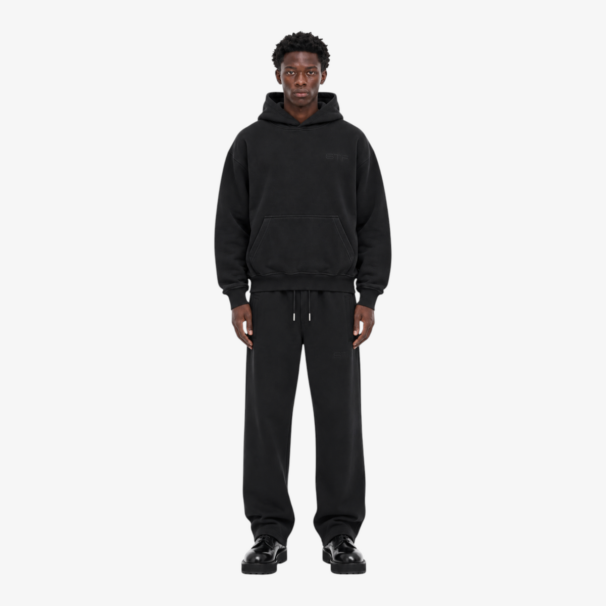 Male model wearing the STF black heavyweight tracksuit, front view