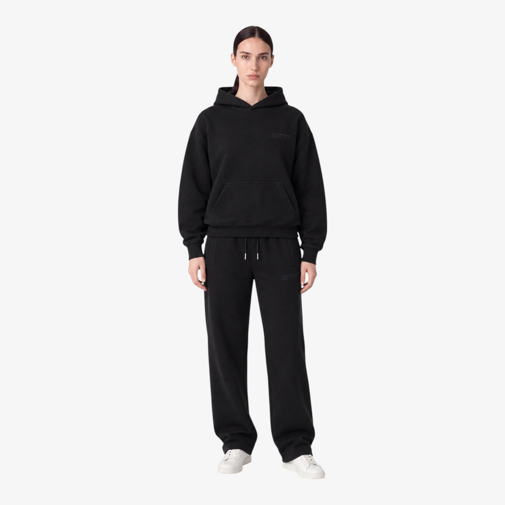 Female model wearing the STF black heavyweight tracksuit, front view