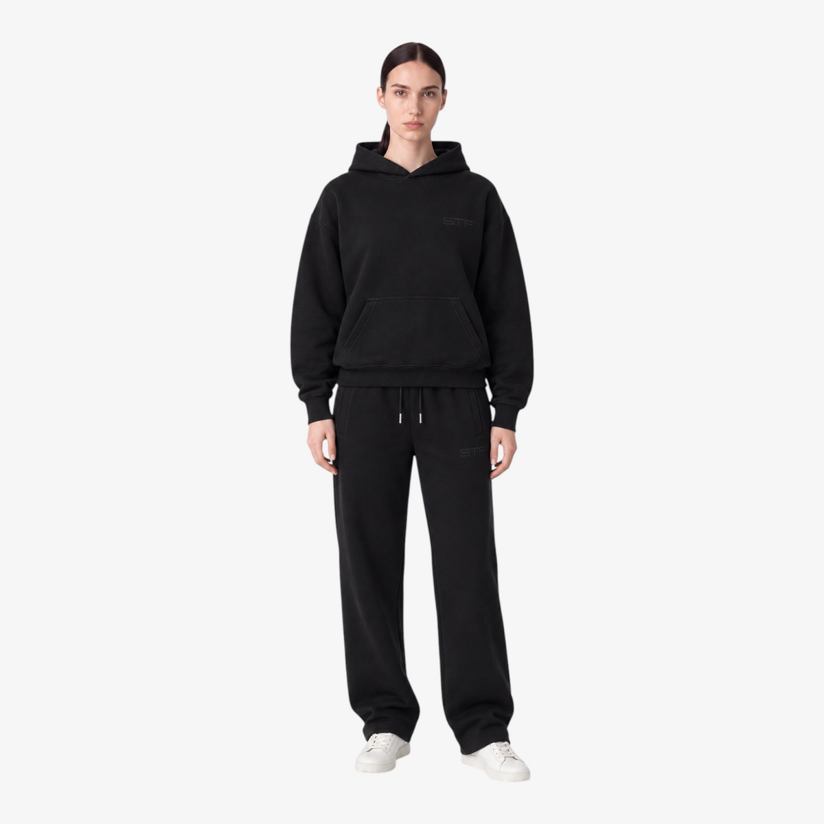 Female model wearing the STF black heavyweight tracksuit, front view